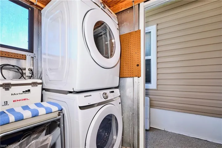 Washroom featuring laundry area and stacked washer / drying machine