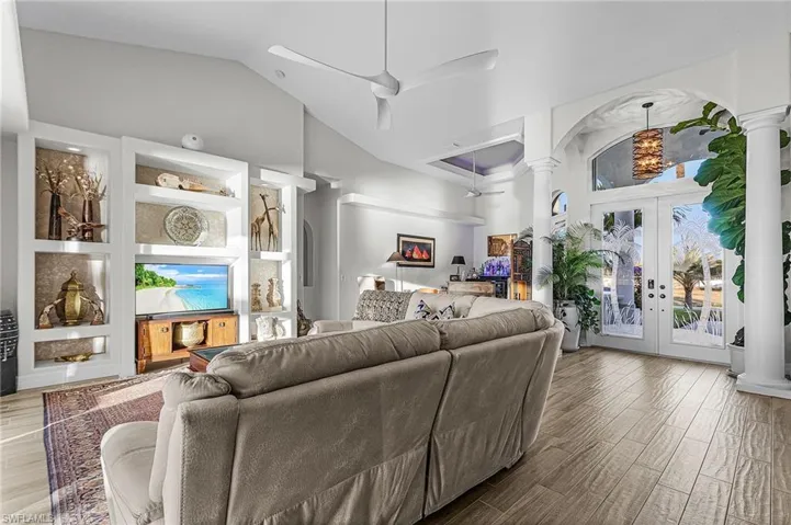 Living room featuring a ceiling fan, french doors, wood finished floors, and high vaulted ceiling