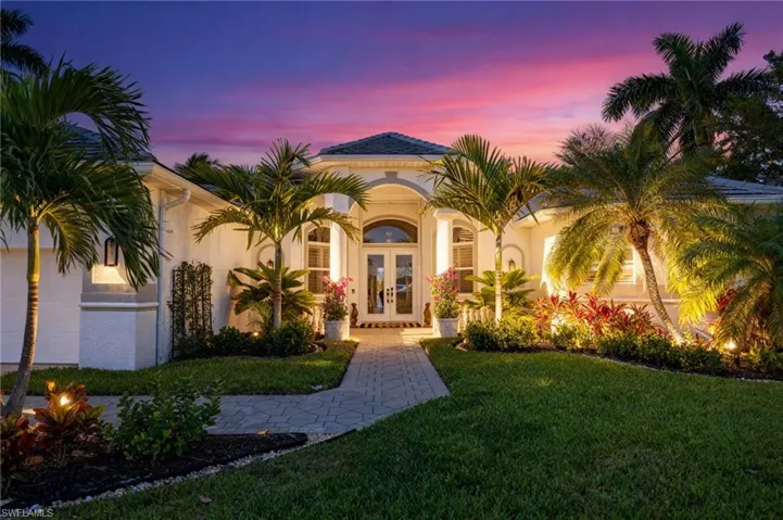 Mediterranean / spanish house with french doors, a front lawn, stucco siding, and a garage