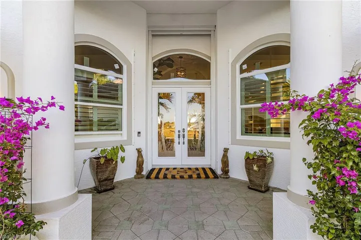 Doorway to property featuring french doors and stucco siding