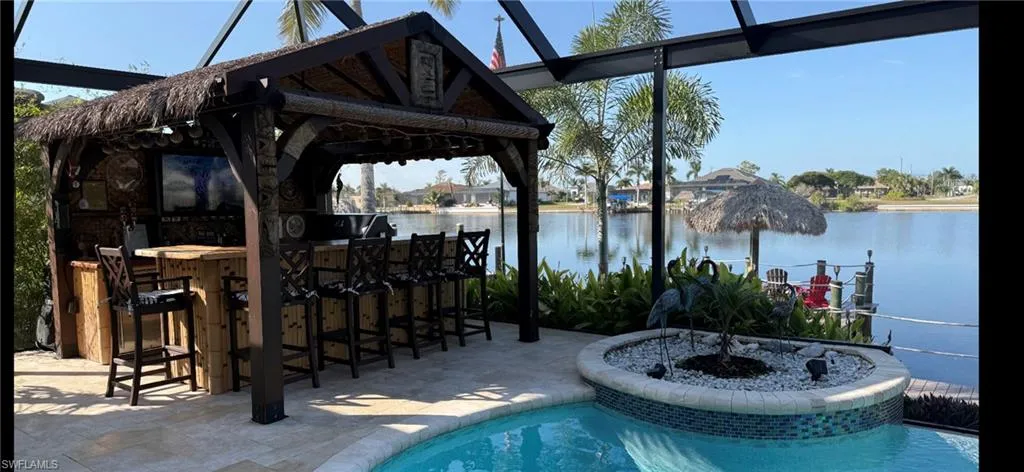 Swimming pool with a patio, a water view, and a lanai