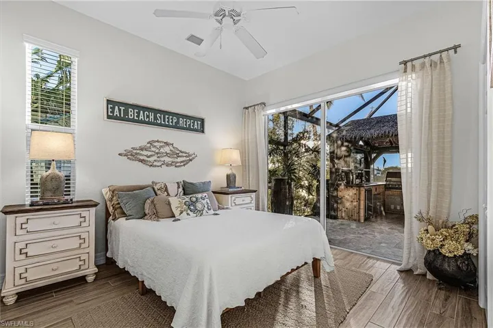 Bedroom with a sunroom, wood finish floors, access to outside, and ceiling fan