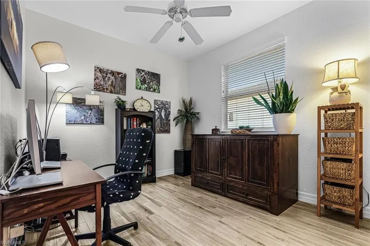 3rd Bedroom being used as a second office area featuring light wood-style flooring, a textured wall, and ceiling fan