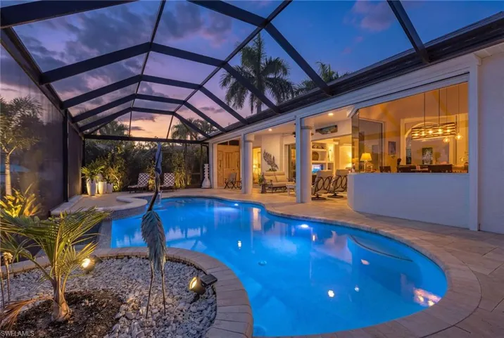 View of pool with a sunroom, a lanai, a pool with connected hot tub, and a patio area