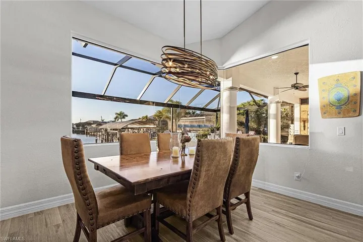 Dining room featuring a textured wall, a sunroom, light wood-style flooring, and ceiling fan