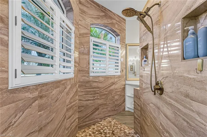 Full bathroom with a marble finish shower