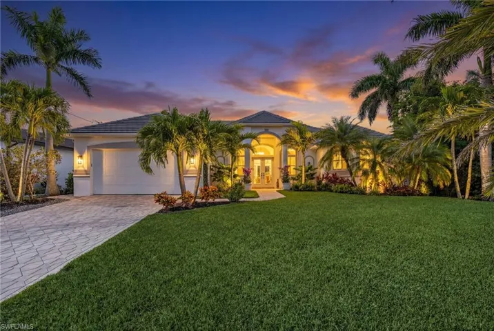 Mediterranean / spanish home featuring a lawn, stucco siding, decorative driveway, a tile roof, and a garage