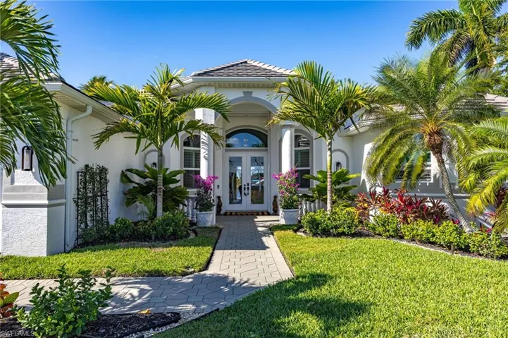 Doorway to property featuring french doors, stucco siding, and a yard