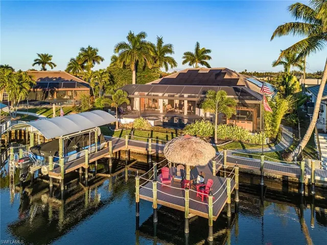Dock featuring boat lift, a water view, a lanai, and a sunroom