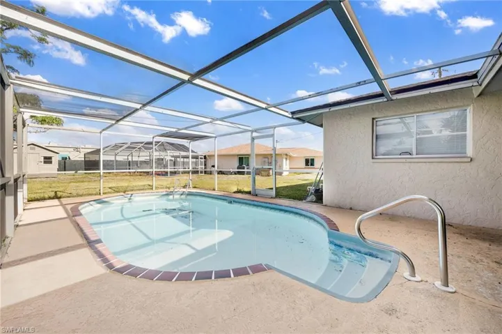 View of swimming pool with glass enclosure, a yard, and a patio
