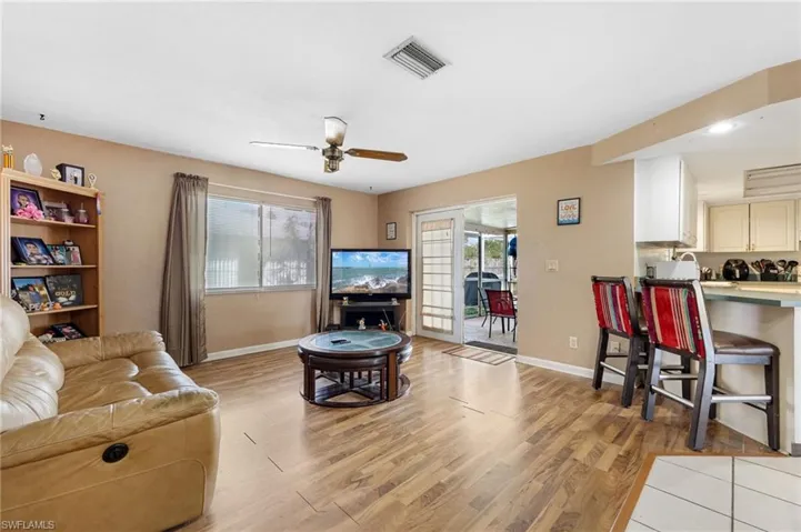 Living room with ceiling fan and light wood-type flooring