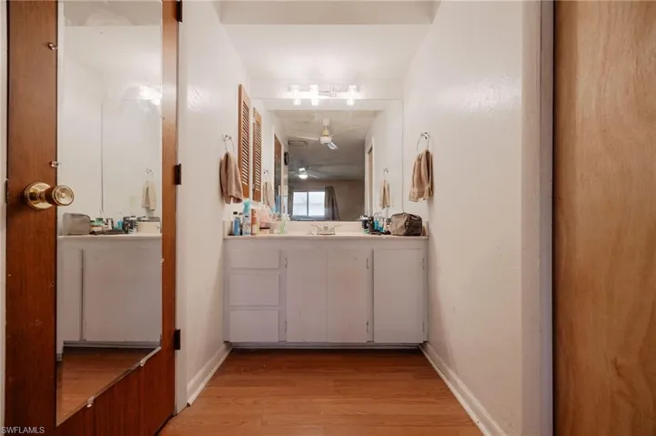 Bathroom with hardwood / wood-style floors, vanity, and ceiling fan