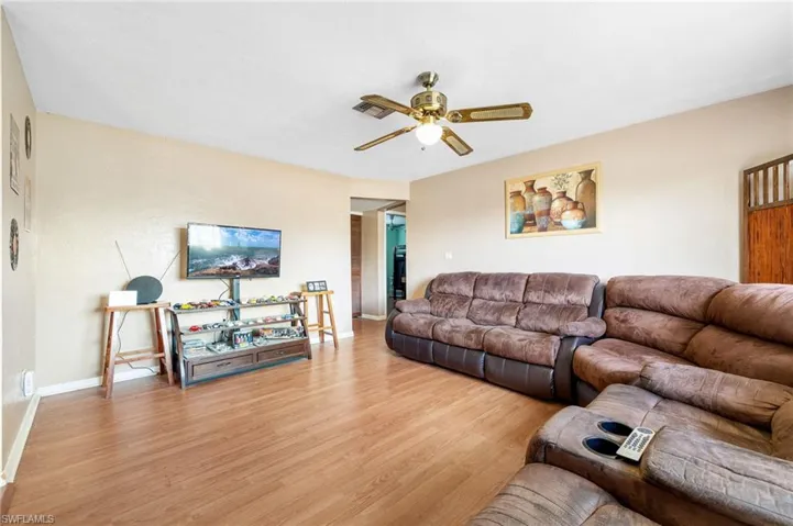 Living room with light hardwood / wood-style flooring and ceiling fan