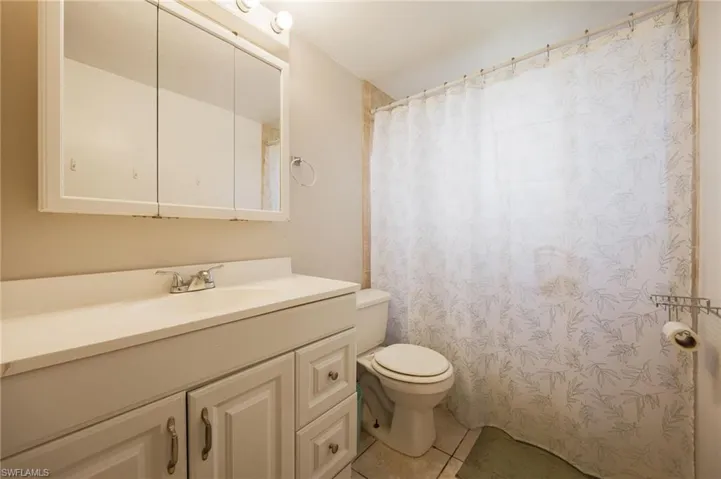 Bathroom featuring toilet, vanity, and tile patterned floors