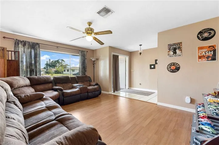 Living room featuring ceiling fan and light hardwood / wood-style flooring