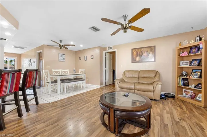 Living room with light hardwood / wood-style flooring and ceiling fan