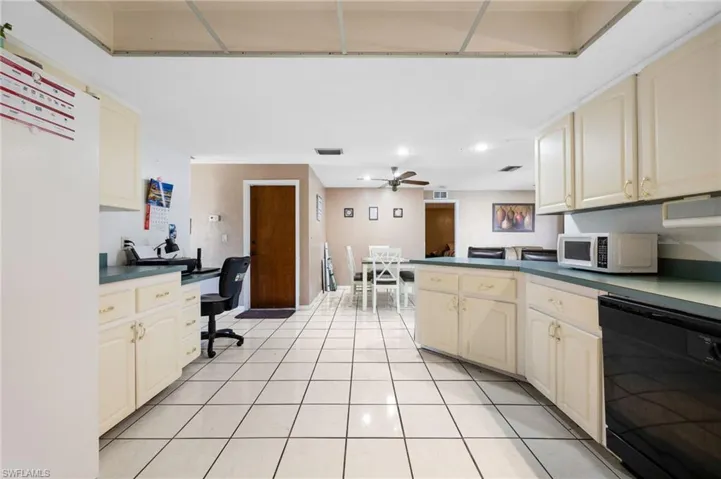 Kitchen with dishwasher, light tile patterned flooring, ceiling fan, and cream cabinets