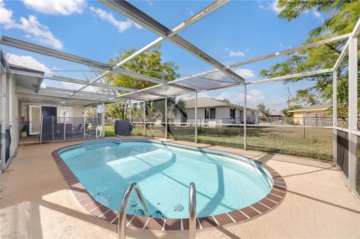 View of pool featuring a lawn, a lanai, and a patio area
