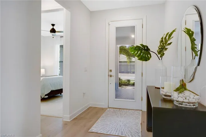 Foyer entrance featuring ceiling fan, light wood-type flooring, and baseboards