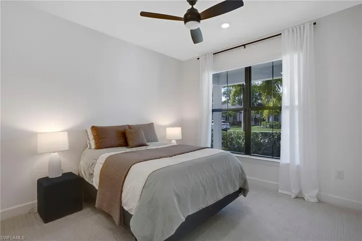 First floor bedroom with baseboards, a ceiling fan, and light colored carpet
