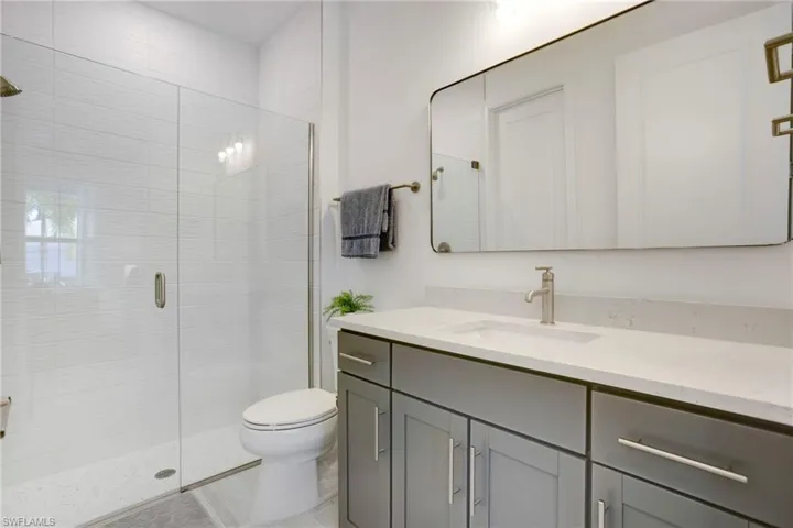 Full bathroom with a shower stall, toilet, and vanity