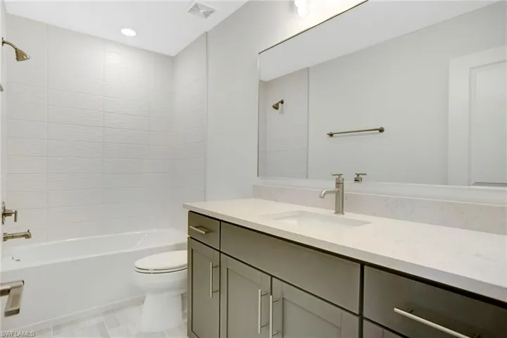 Bathroom with visible vents, toilet, shower / bathtub combination, vanity, and recessed lighting
