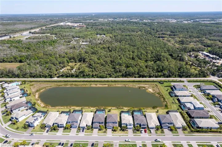 Drone / aerial view featuring a water view, a residential view, and a wooded view