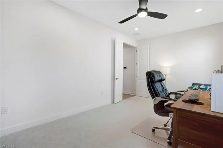 Office space featuring a ceiling fan, recessed lighting, light carpet, and baseboards