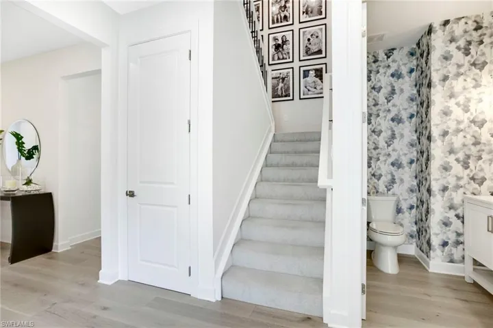 Staircase with wood finished floors and baseboards