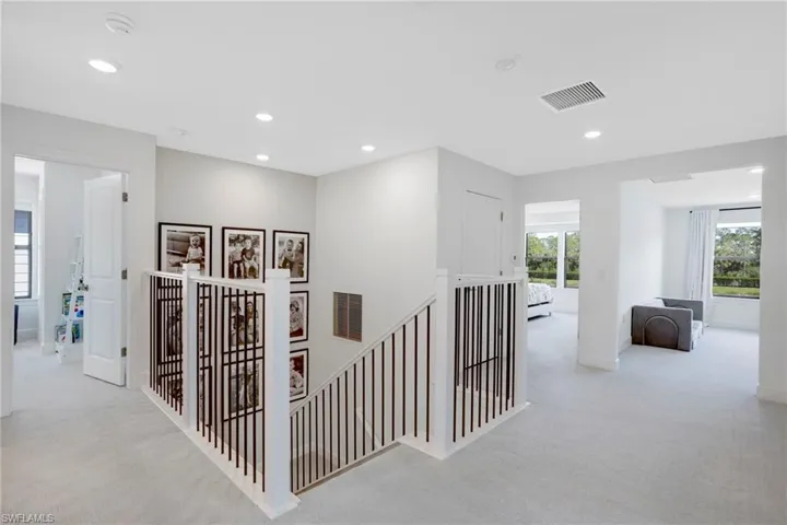 Hallway with recessed lighting, carpet flooring, visible vents, and an upstairs landing