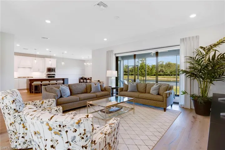 Living room featuring light wood-type flooring, visible vents, and recessed lighting