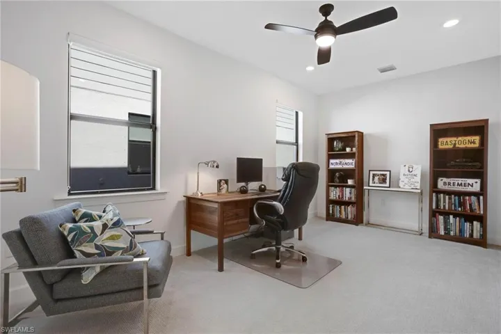 Office space featuring carpet floors, recessed lighting, visible vents, and ceiling fan