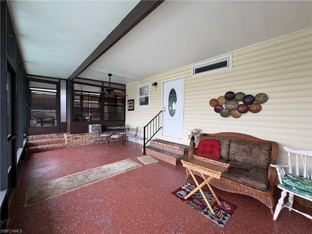 View of front screened Sunroom featuring entry steps, beam ceiling, a patio, wooden walls, and ceiling fan