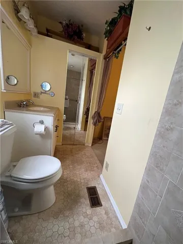 View of Primary's updated/renovated Primary's Full bathroom with vanity, a textured ceiling, and light tile patterned floors and walk in tiled shower.
