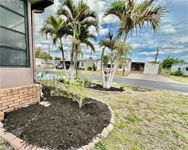 View from the south front corner of newly mulched garden and front entrance palms/garden