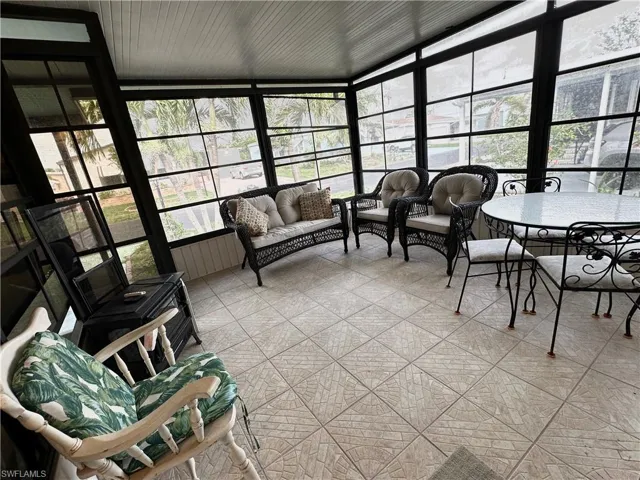 View of huge scrreened Sunroom / solarium featuring floor to ceiling windows and tile patterned floors