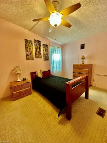 View of good-sized Second Bedroom featuring ceiling fan, a textured ceiling
