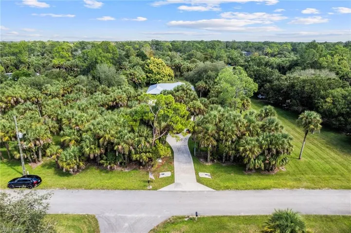 Property is set back from the road offering a private drive surrounded by trees and greenery.