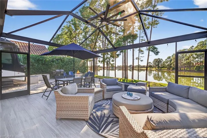 View of patio featuring a sunroom, outdoor dining area, a water view, and outdoor lounge area
