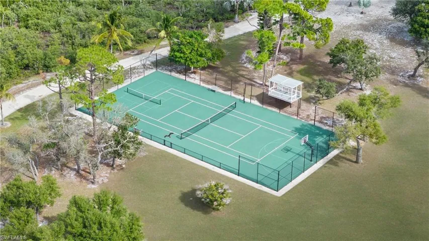 SPORT COURT - The property features a well-maintained tennis court with a basketball hoop, enclosed by a fence
