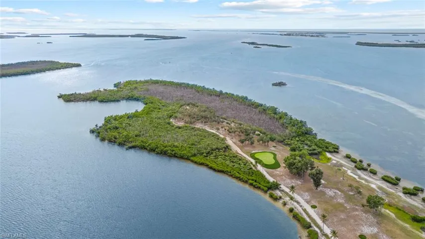 AERIAL ISLAND - Aerial view of the property's waterfront location, featuring a golf green and surrounding islands