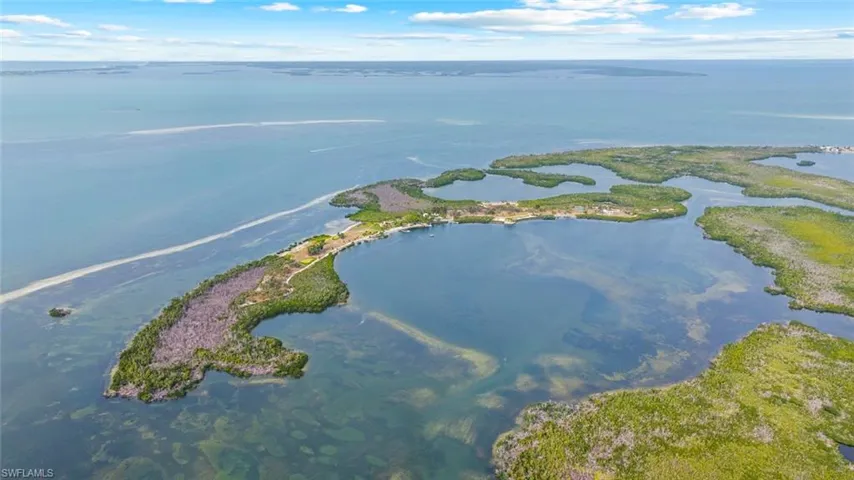 Burgess Island Aerial view showcasing the private island's  waterfront location, surrounded by clear blue waters and lush green vegetation
