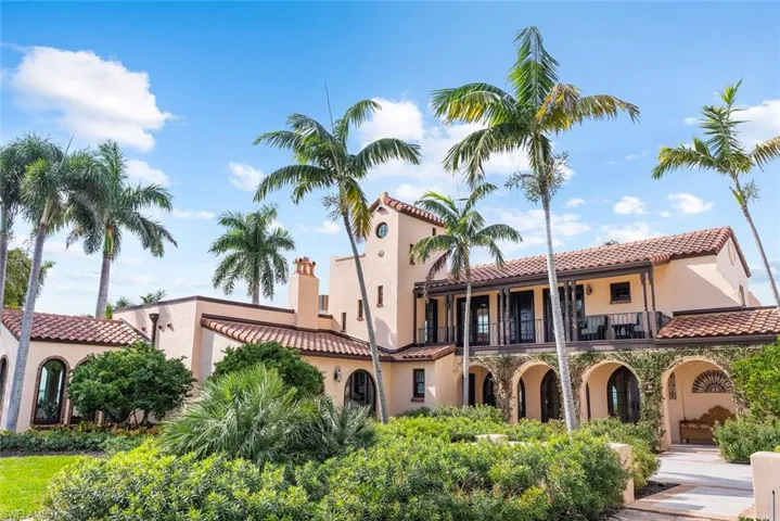 MAIN HOUSE - The property features a Mediterranean-style exterior with arched walkways, terra cotta roof tiles, and an upper-level balcony