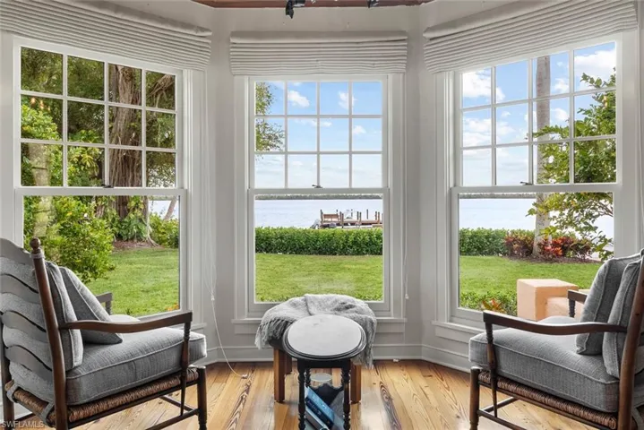 ATTACHED GUEST HOUSE - This property features a bay window with wood flooring and views of a body of water, a dock, and mature trees