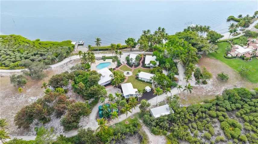 VILLAGE, CLUBHOUSE, GUEST COTTAGES "OLD TOWN" - Aerial view of the property featuring several white-roofed structures, a swimming pool, and a private dock leading to the waterfront
