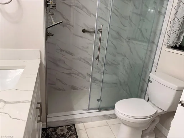 Shower enclosure featuring glass doors and a brushed nickel handle