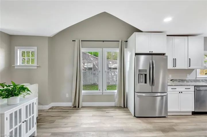 Kitchen featuring appliances with stainless steel finishes, white cabinetry, healthy amount of natural light, light wood finished floors, and recessed lighting