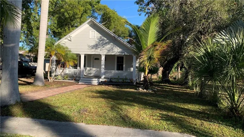 Bungalow-style house with brick walkway leading to covered porch