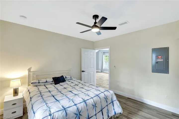 Bedroom featuring electric panel, wood finished floors, and ceiling fan