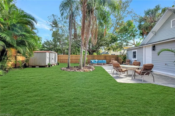 Fenced backyard featuring an outdoor hangout area, a storage shed, and a patio area
